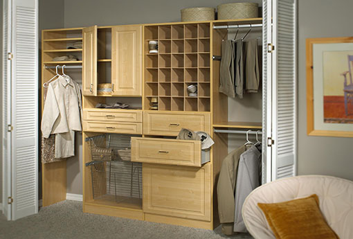 a closet with multiple drawers, hanging spaces and a shoe cubbies