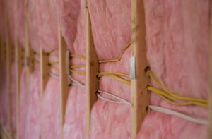 Pink fiberglass insulation installed in a wall.