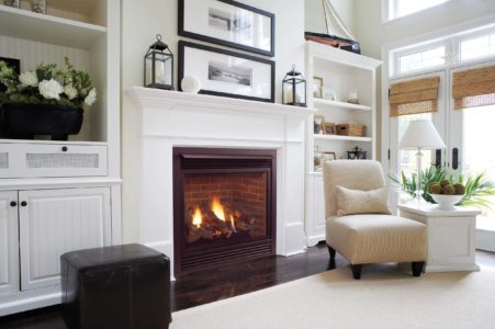 Fireplace installed with white mantel and surrounding built-in shelving in a living room.