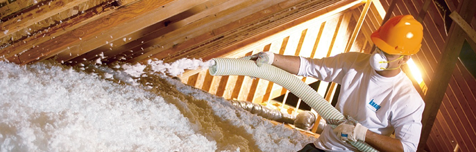 A service technician pouring insulation