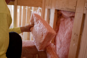 Installing pink insulation in wall